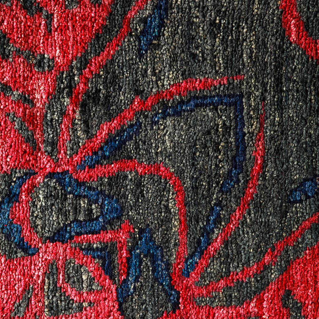 Close-up of colorful, textured fabric with red accents, possibly carpet.