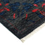 Densely woven handcrafted rug exhibits intricate floral motifs in vibrant colors.