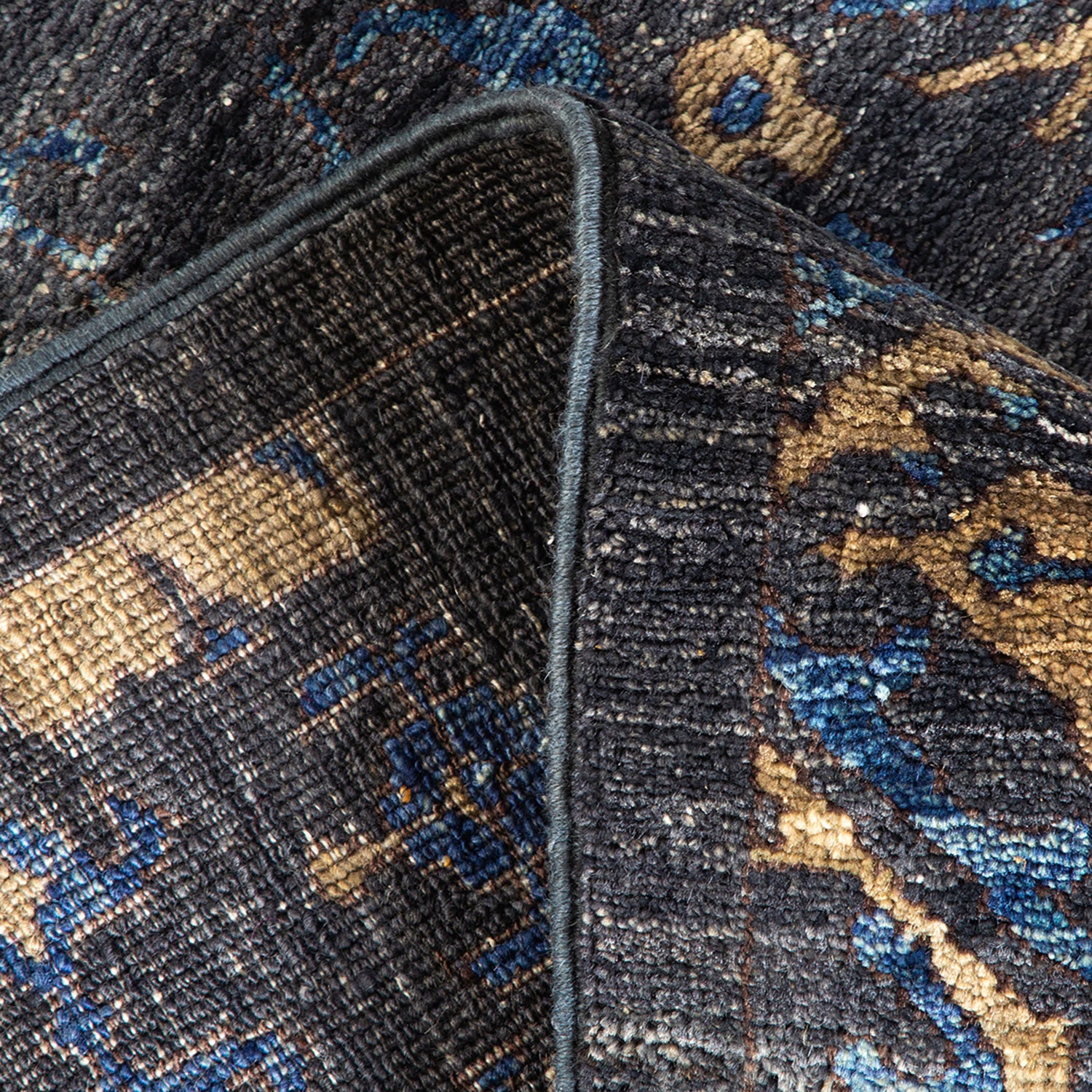 Close-up image of textured fabric with intricate blue pattern and visible seam.