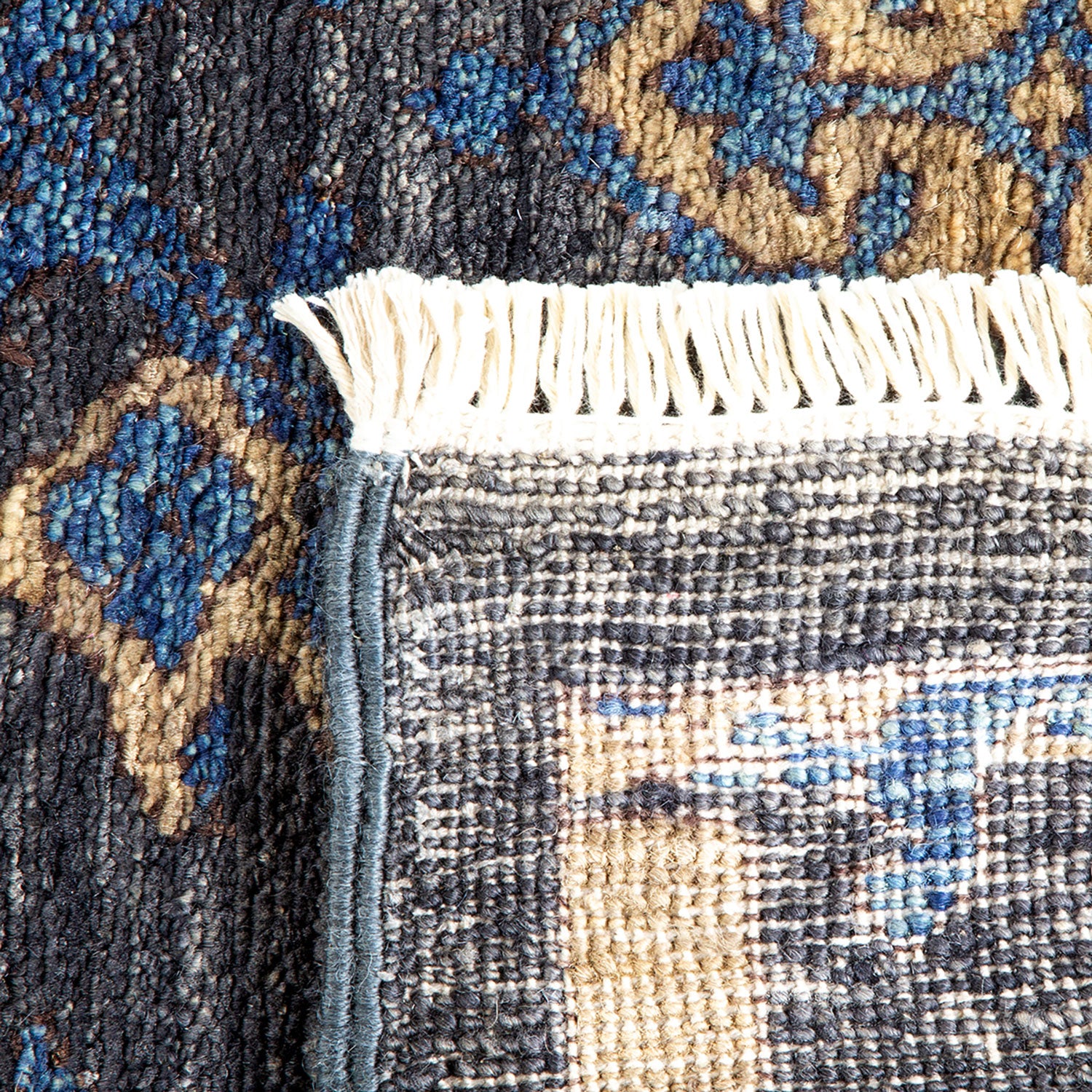 Close-up of a high-quality, detailed patterned rug with white fringe.