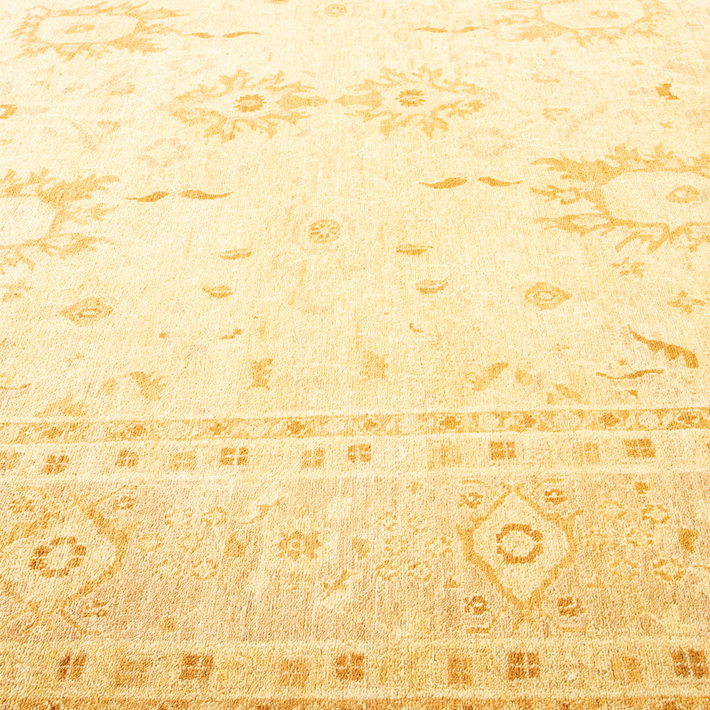 Patterned vintage rug with faded designs in golden beige tones.