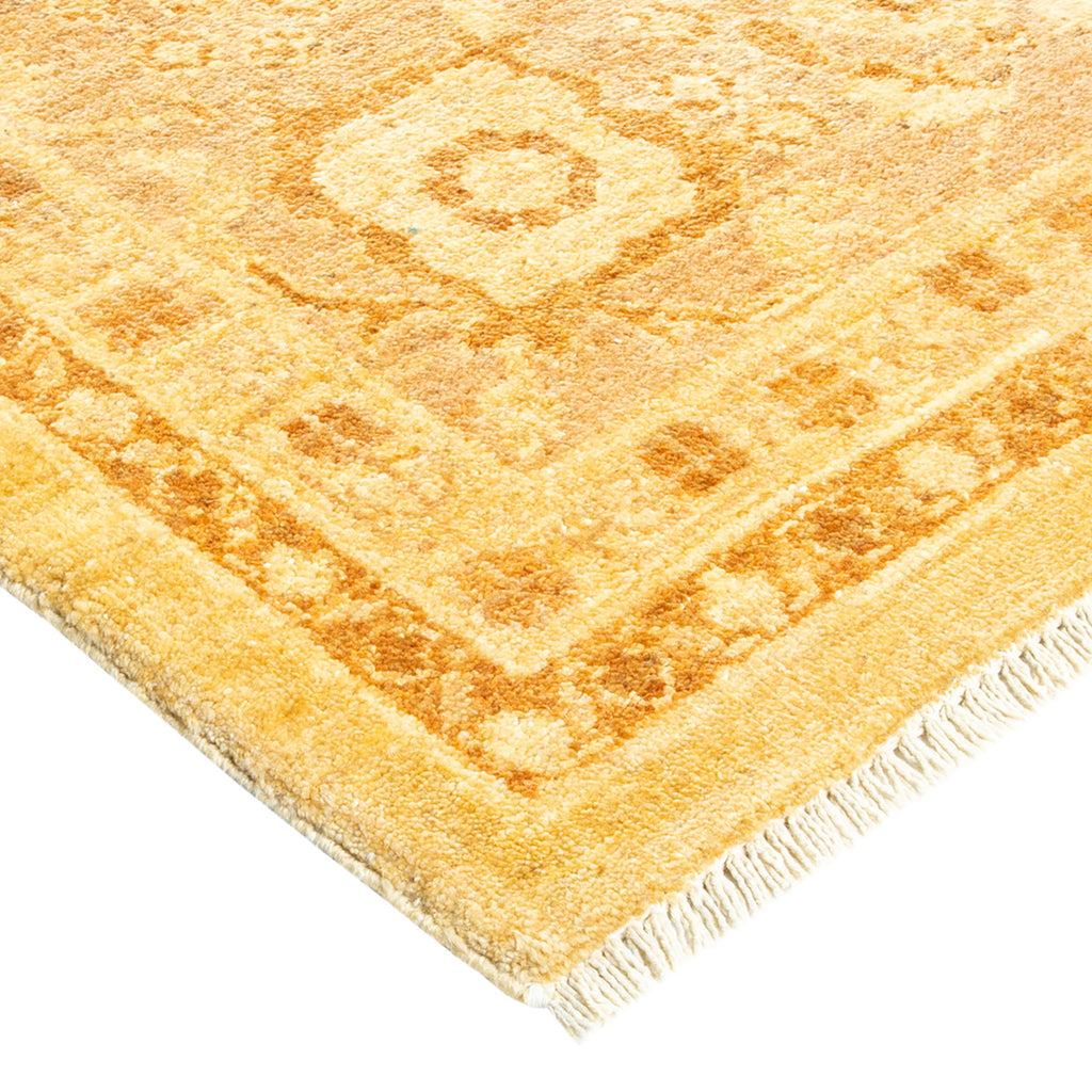 Luxurious, hand-woven rug with symmetrical gold geometric patterns and fringe.