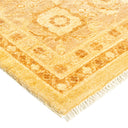 Luxurious, hand-woven rug with symmetrical gold geometric patterns and fringe.