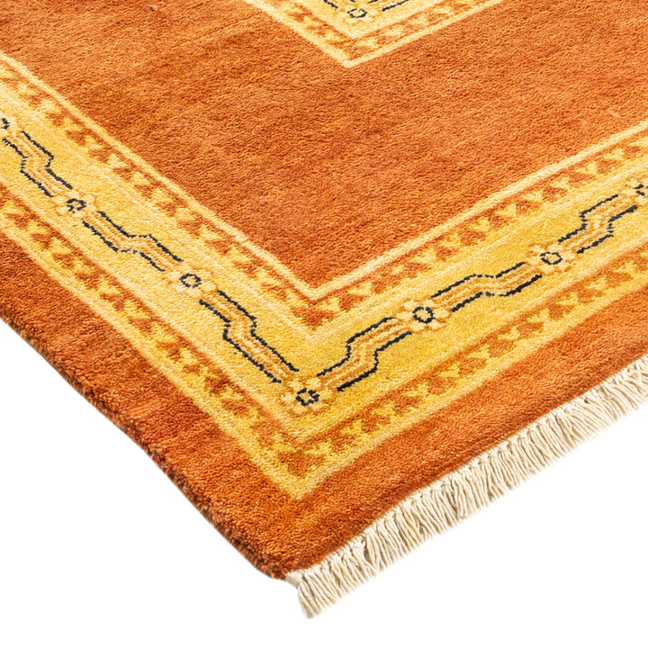 Burnt orange and golden geometric patterned rug with plush pile