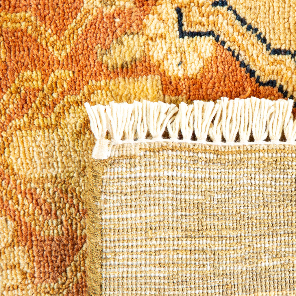 Intricate woven rug with vibrant design and textured fringed edges.