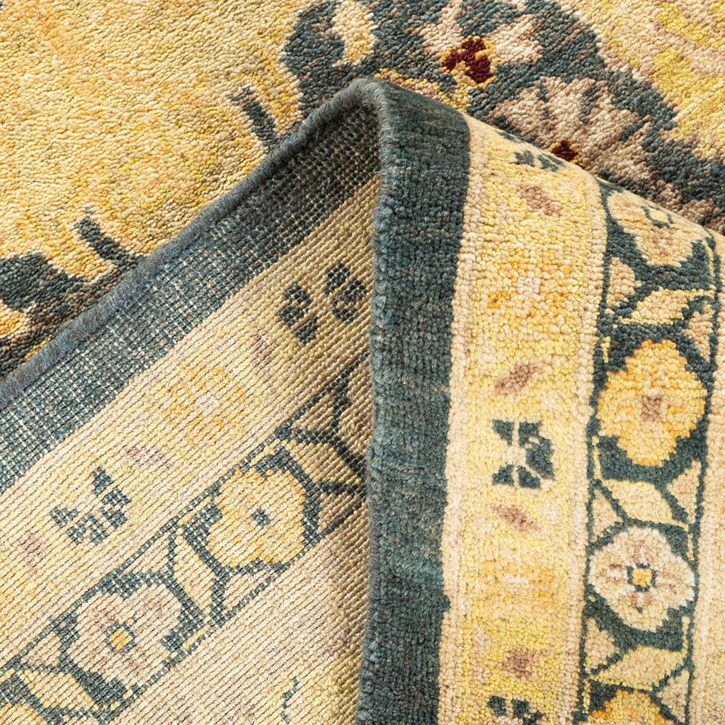 Close-up of folded ornate rug with intricate patterns and vibrant colors.