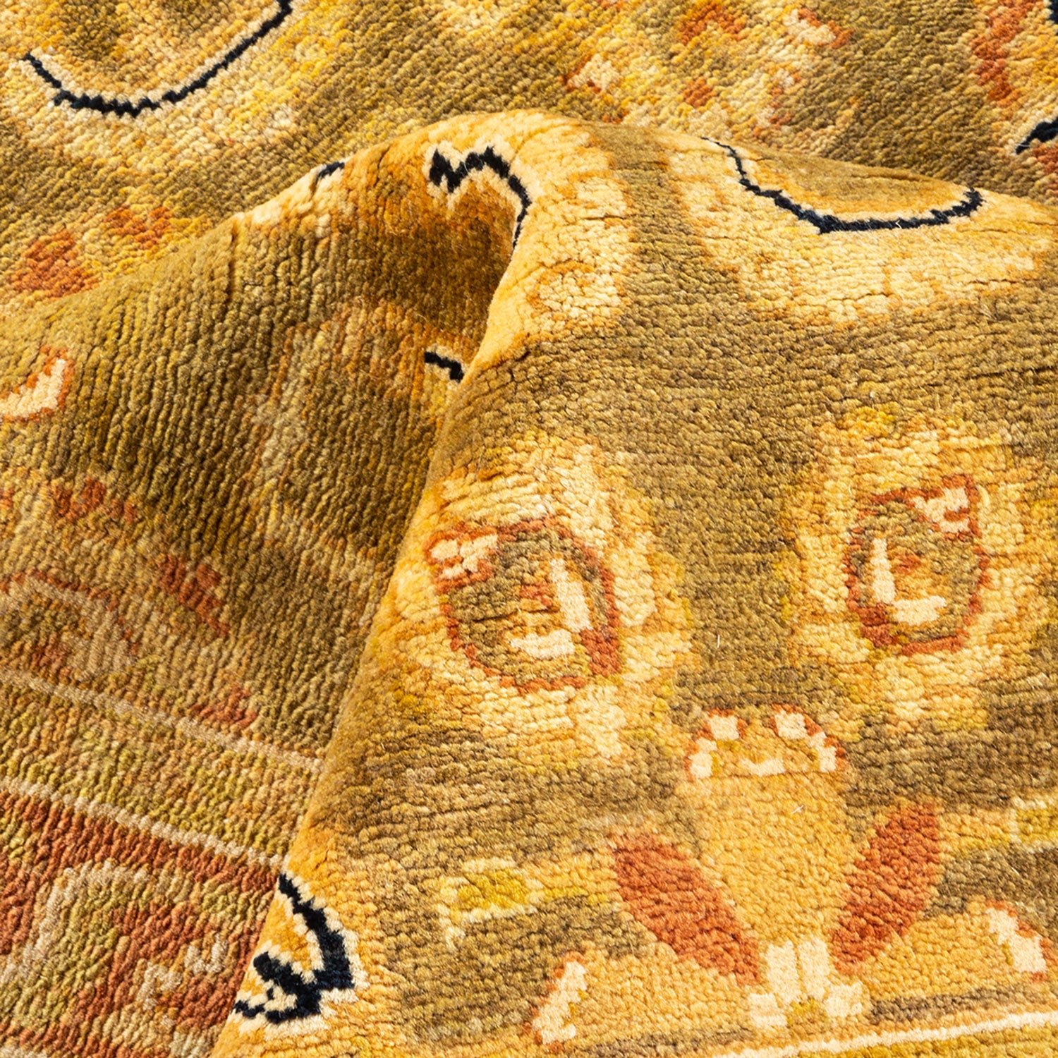 Close-up of a thick, warm-toned traditional rug with intricate design.