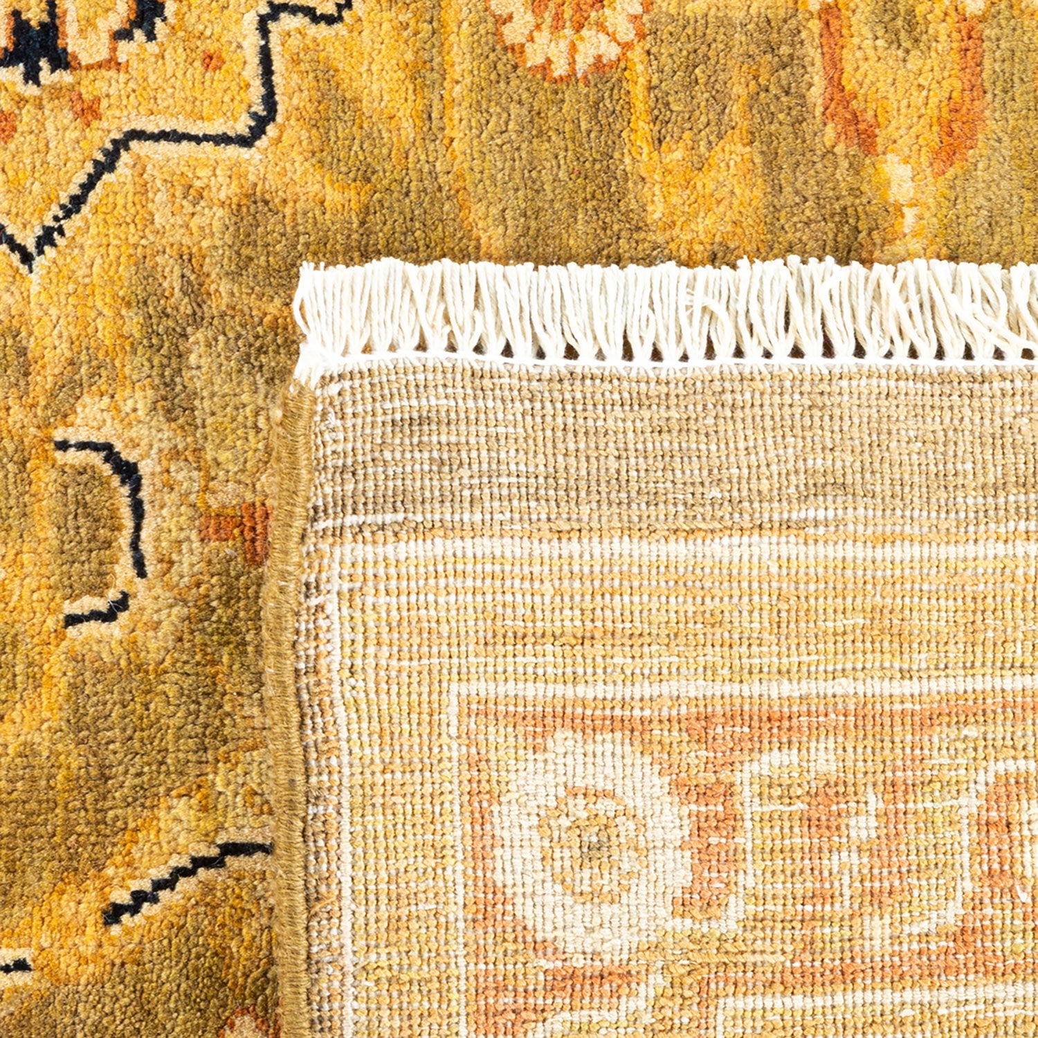 Close-up of a colorful traditional rug with geometric patterns and fringe.