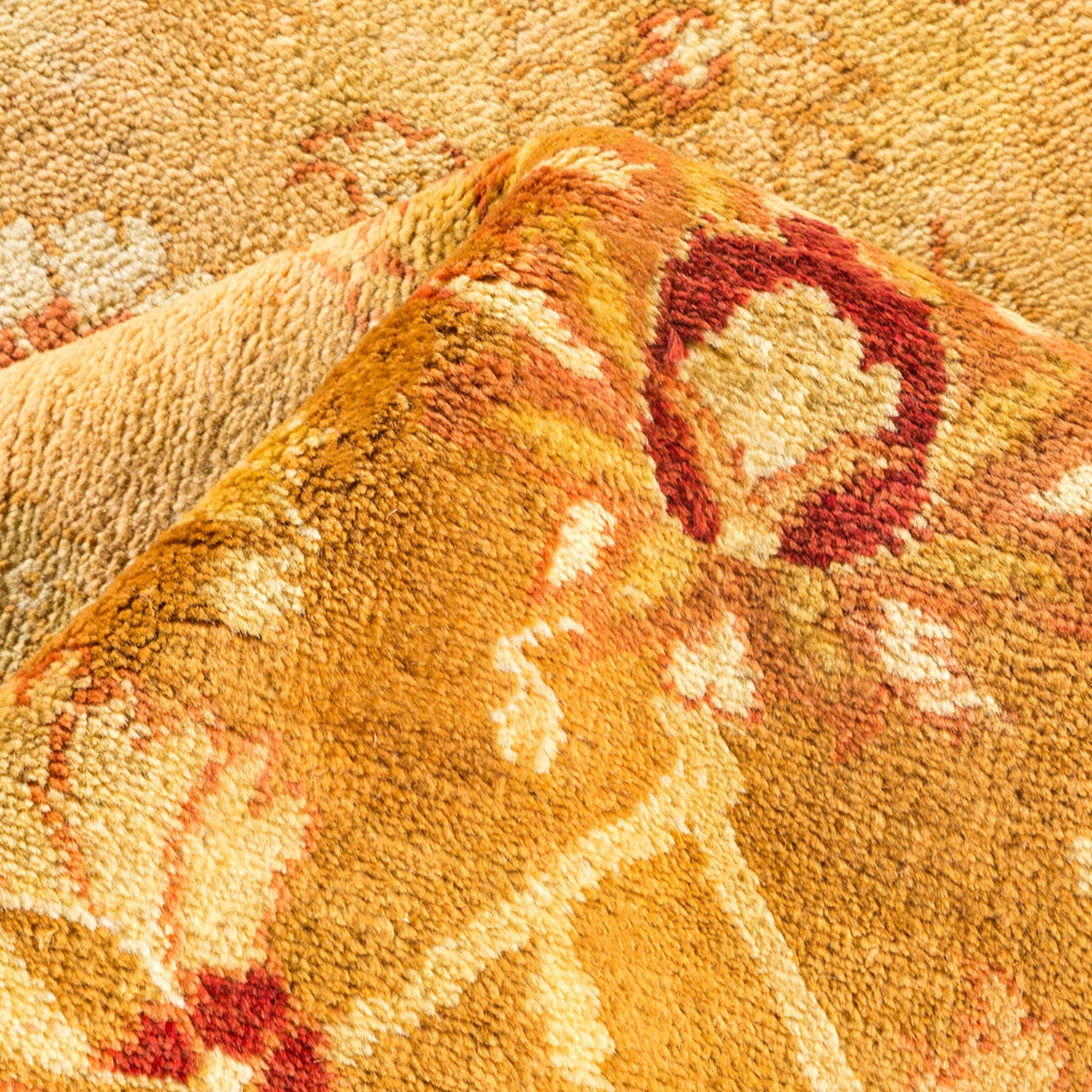 Close-up of intricately woven, textured rug with folded corner.