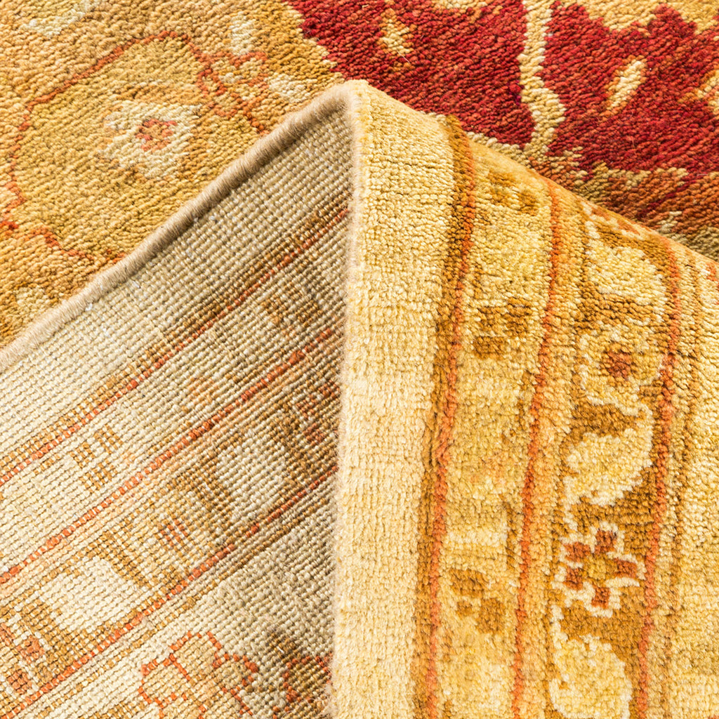 Close-up of intricately patterned folded carpet with warm colors and symbols.