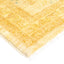 Yellow-gold, plush rug with geometric patterns and fringe detail.