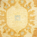 Close-up of a plush, golden yellow patterned carpet with floral-like motifs