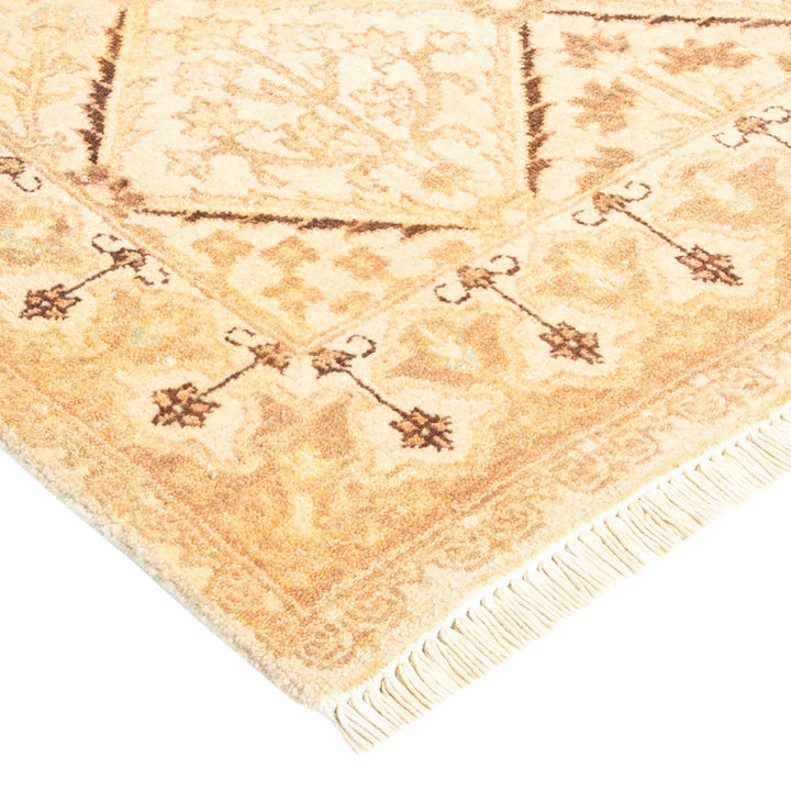 Intricate traditional rug with brown, tan, and cream motifs.