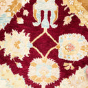 Intricate traditional rug with bold red background and floral motifs