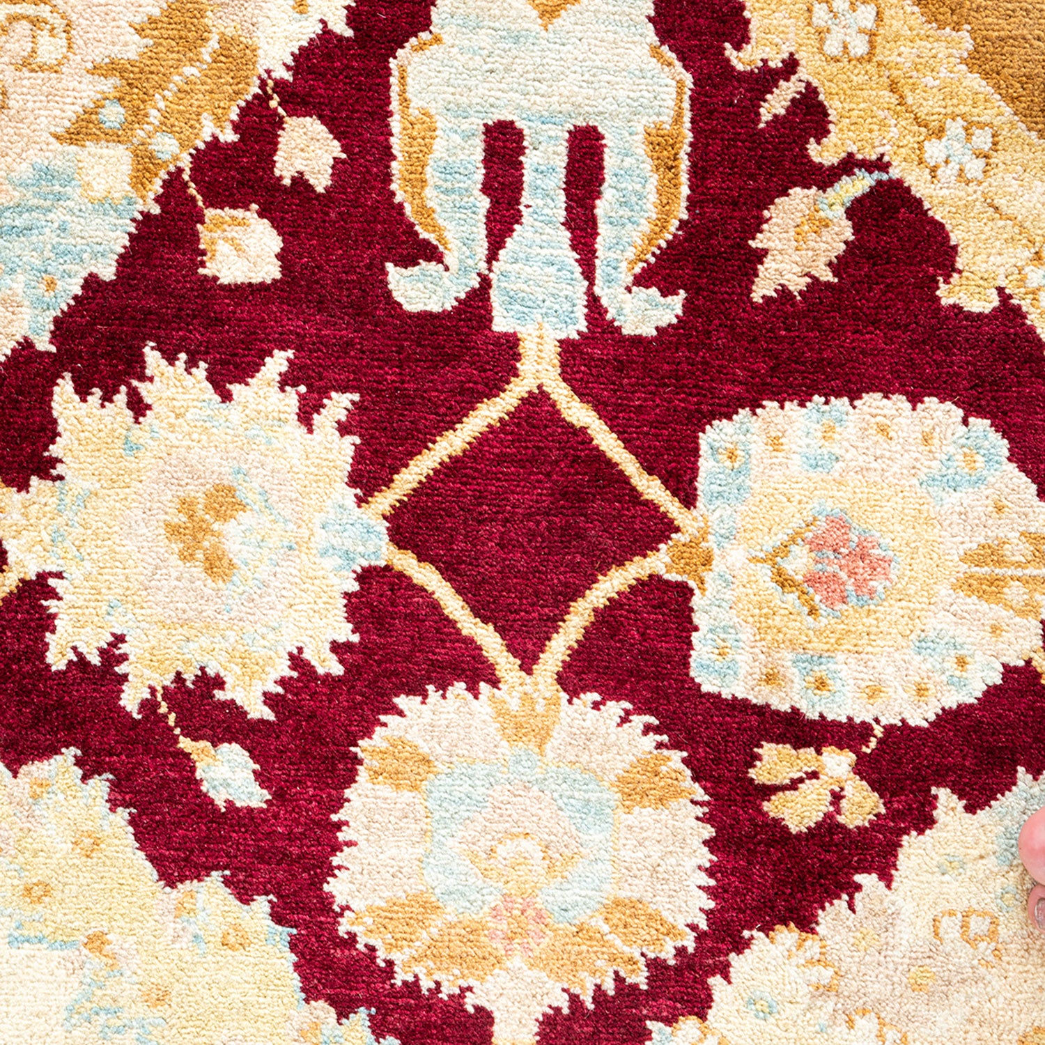 Intricate traditional rug with bold red background and floral motifs