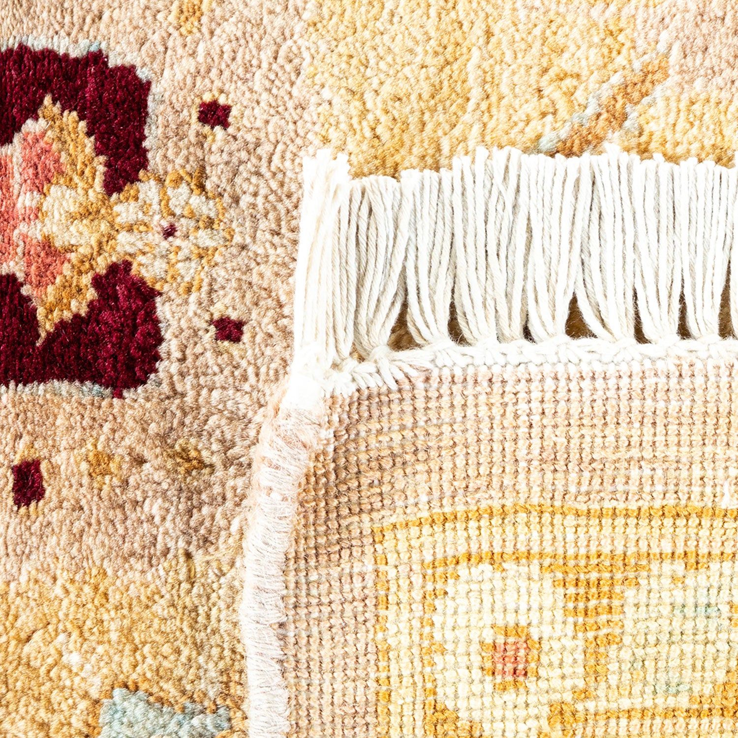 Close-up view of a colorful, intricate woven rug with fringe.