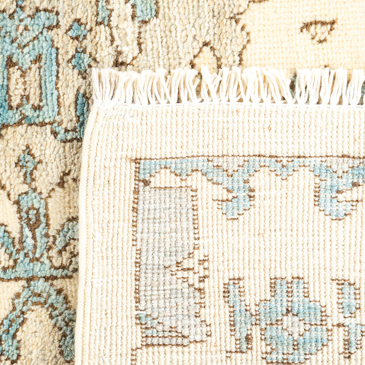 Vintage handwoven rug with intricate floral design and distressed fringe.