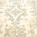Intricate, symmetrical rug with floral motifs in beige and blue.