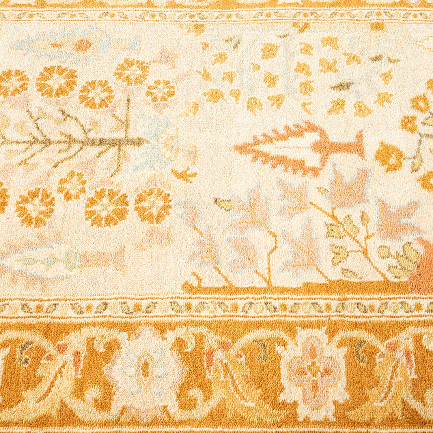 Close-up view of a patterned carpet with warm golden hues