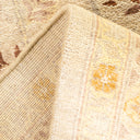 Close-up of soft, plush folded carpet showcases intricate floral design.