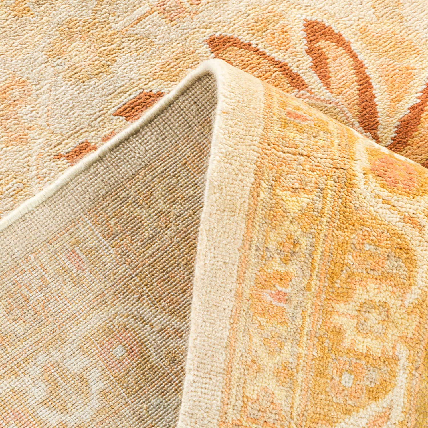 Close-up of folded area rug with plush pile and decorative pattern.