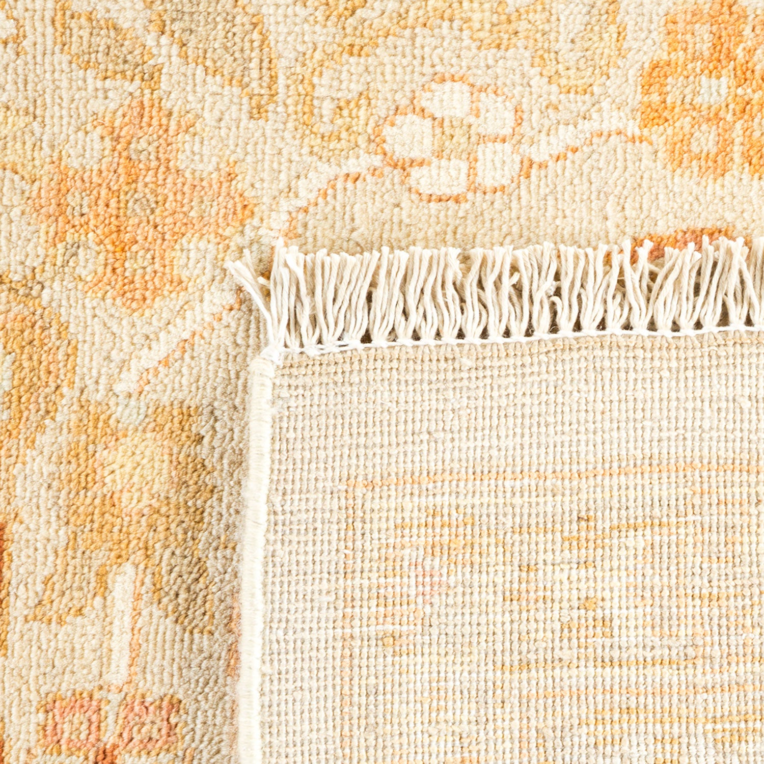 Close-up of a textile rug with cream and orange patterns