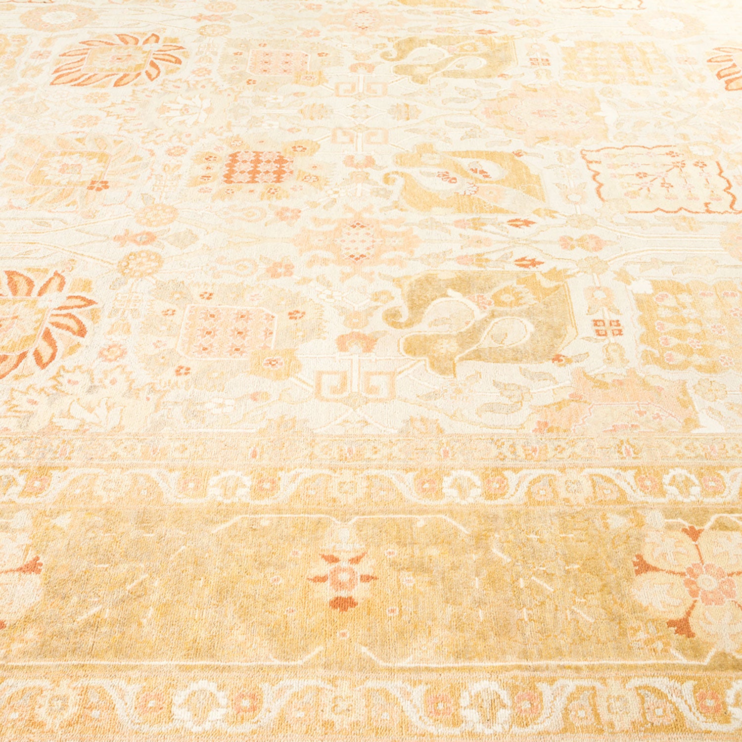 Close-up view of a intricately designed beige and orange carpet.