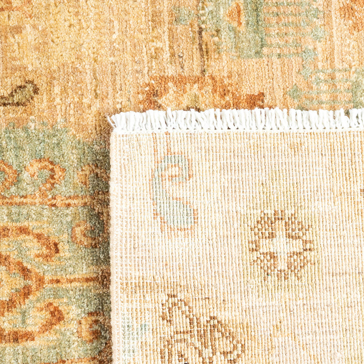 Close-up of vintage rug with beige, orange, and green tones.