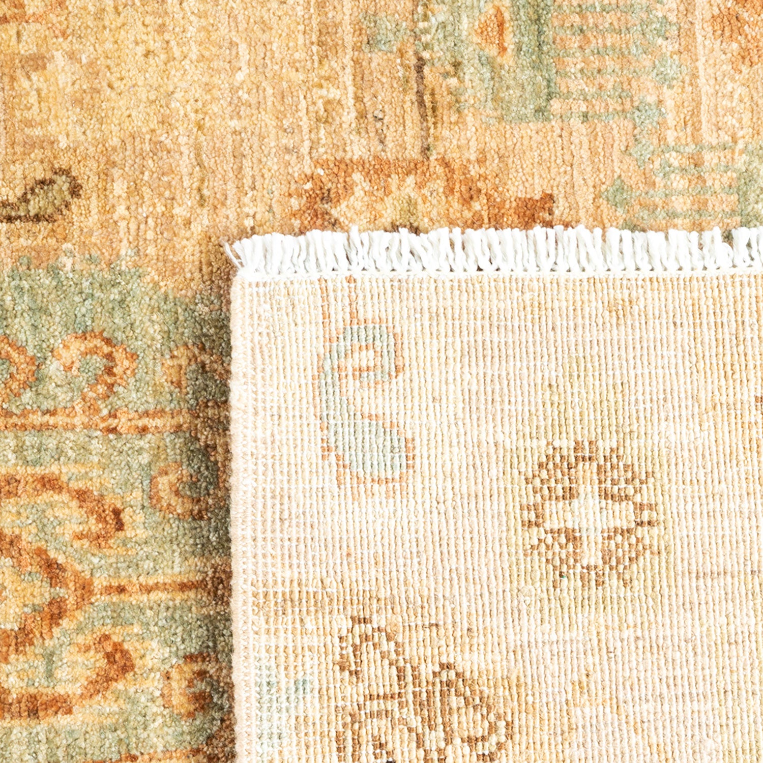 Close-up of vintage rug with beige, orange, and green tones.