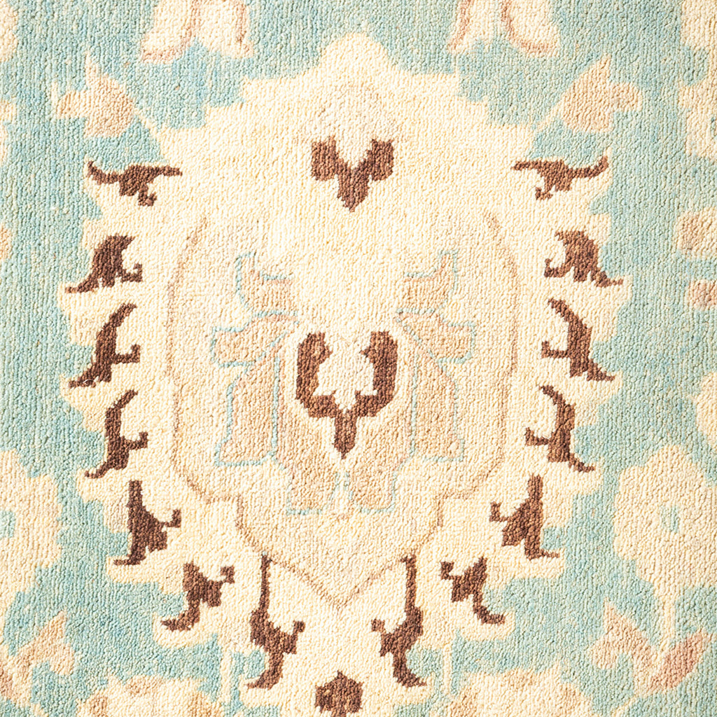 Intricate traditional textile with symmetrical pattern in shades of blue and beige.