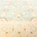 Antique-style carpet with symmetrical floral motifs in soft blue.