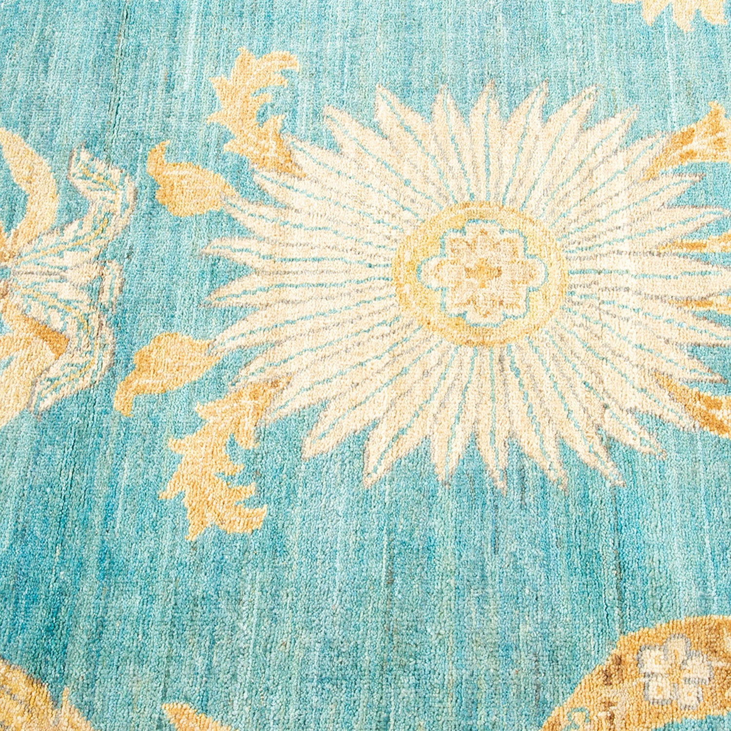 Vibrant turquoise carpet with starburst pattern and ornate floral details.