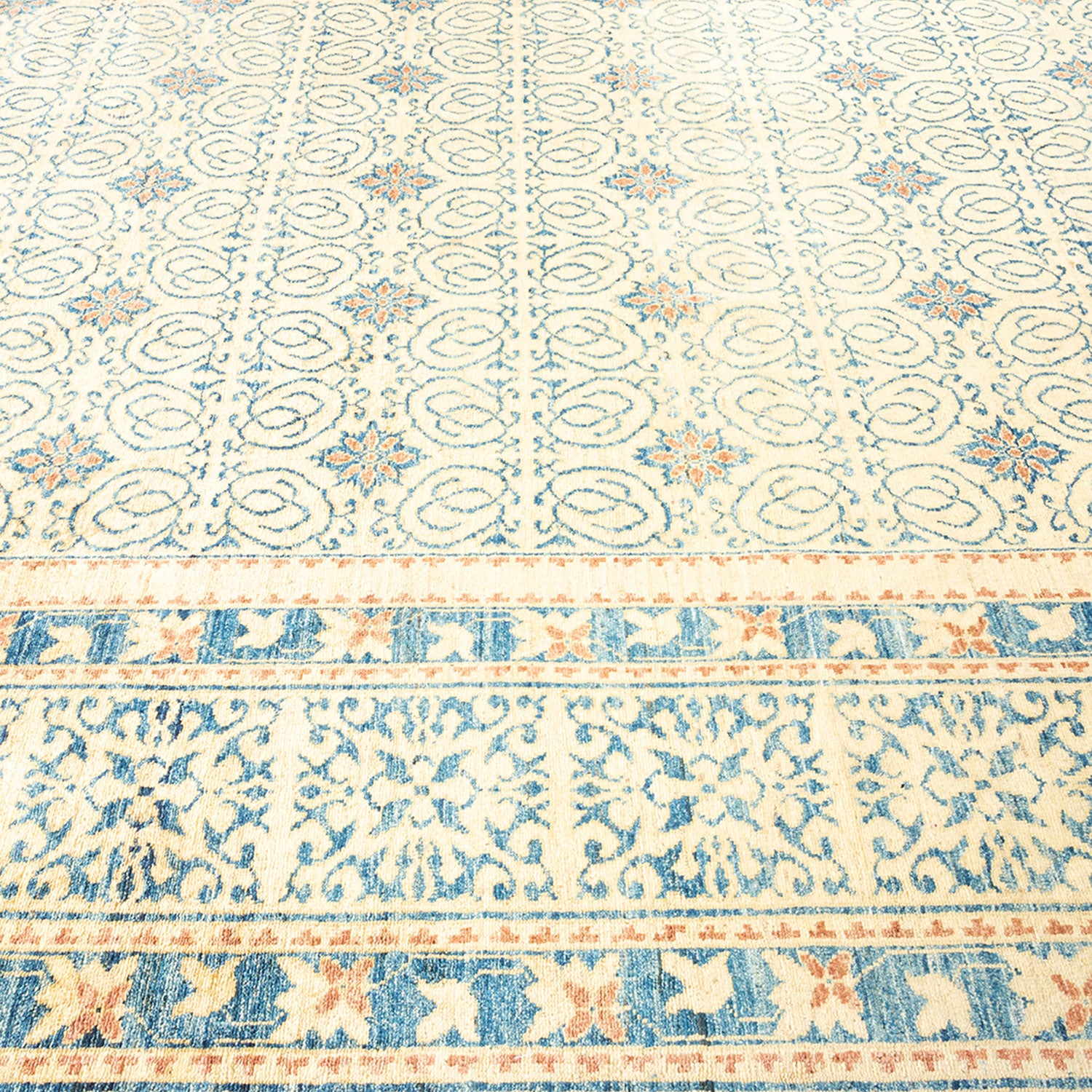 Elegant patterned carpet with traditional motifs in soft, delicate hues.