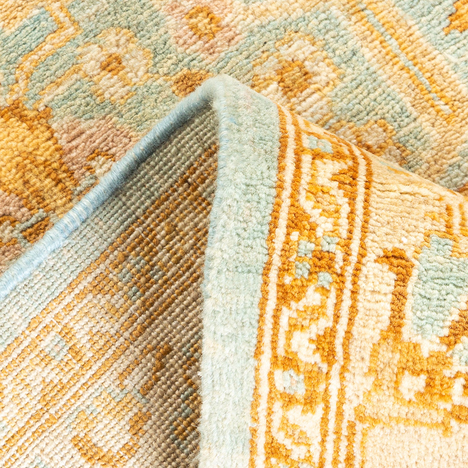 Close-up of a plush, colorful carpet with a folded corner.