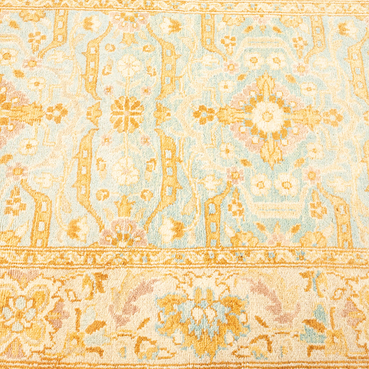 Close-up of a patterned carpet with intricate floral and geometric designs.