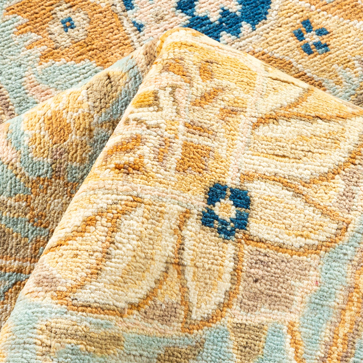 Close-up of a patterned carpet with folded corner showcasing design