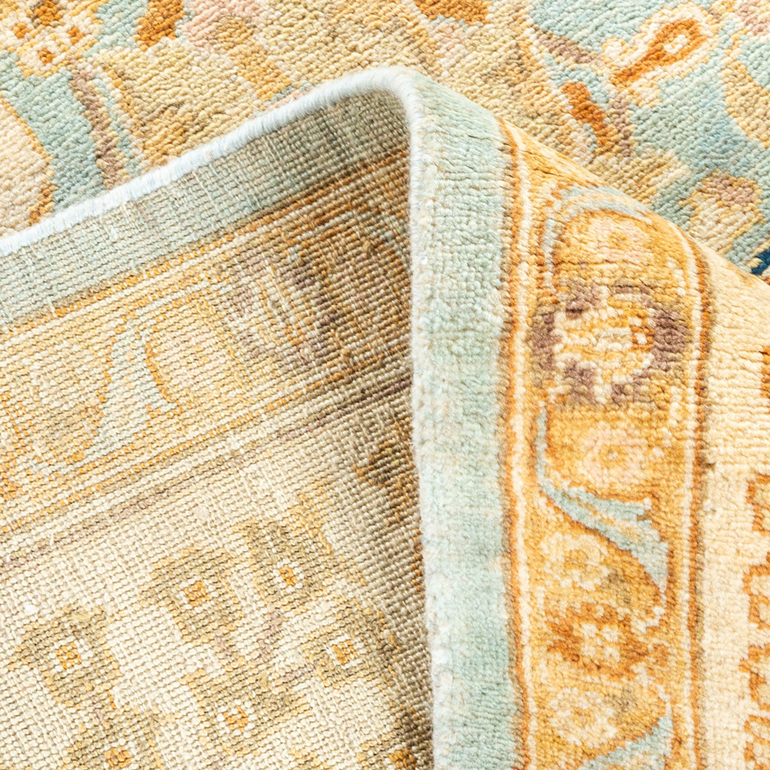 Close-up of a plush, intricately patterned rug with soft colors.
