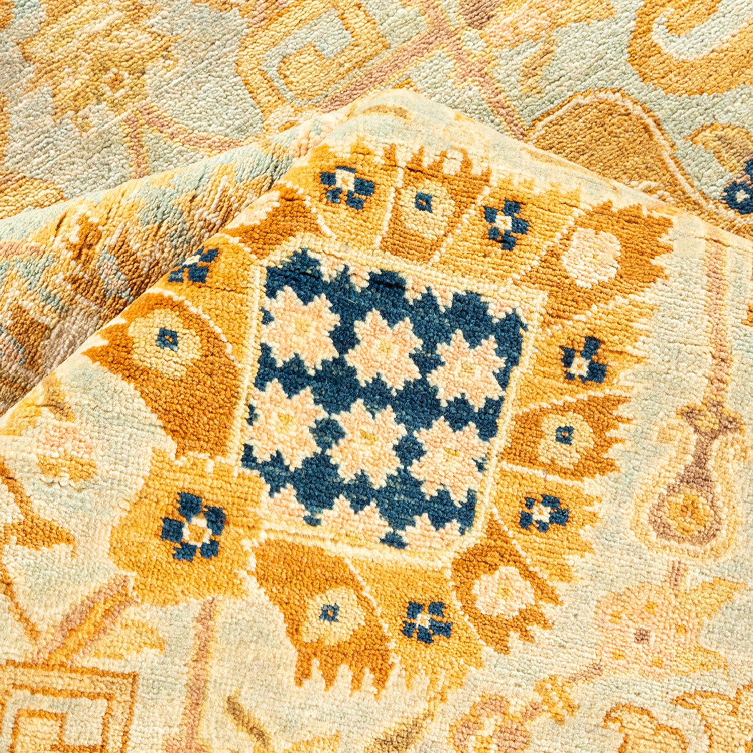 Close-up of a patterned rug with intricate designs in blue and orange.