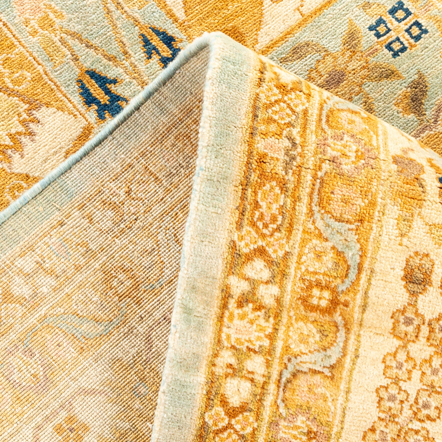 Intricate patterns and rich colors adorn a folded wool rug.
