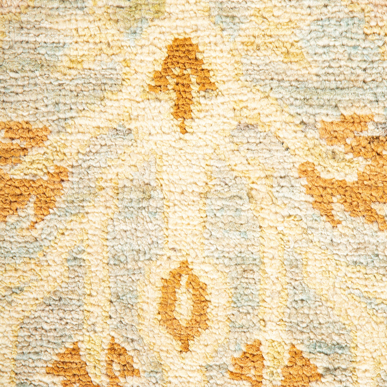 Close-up of plush carpet with symmetrical arrow-like pattern in muted colors