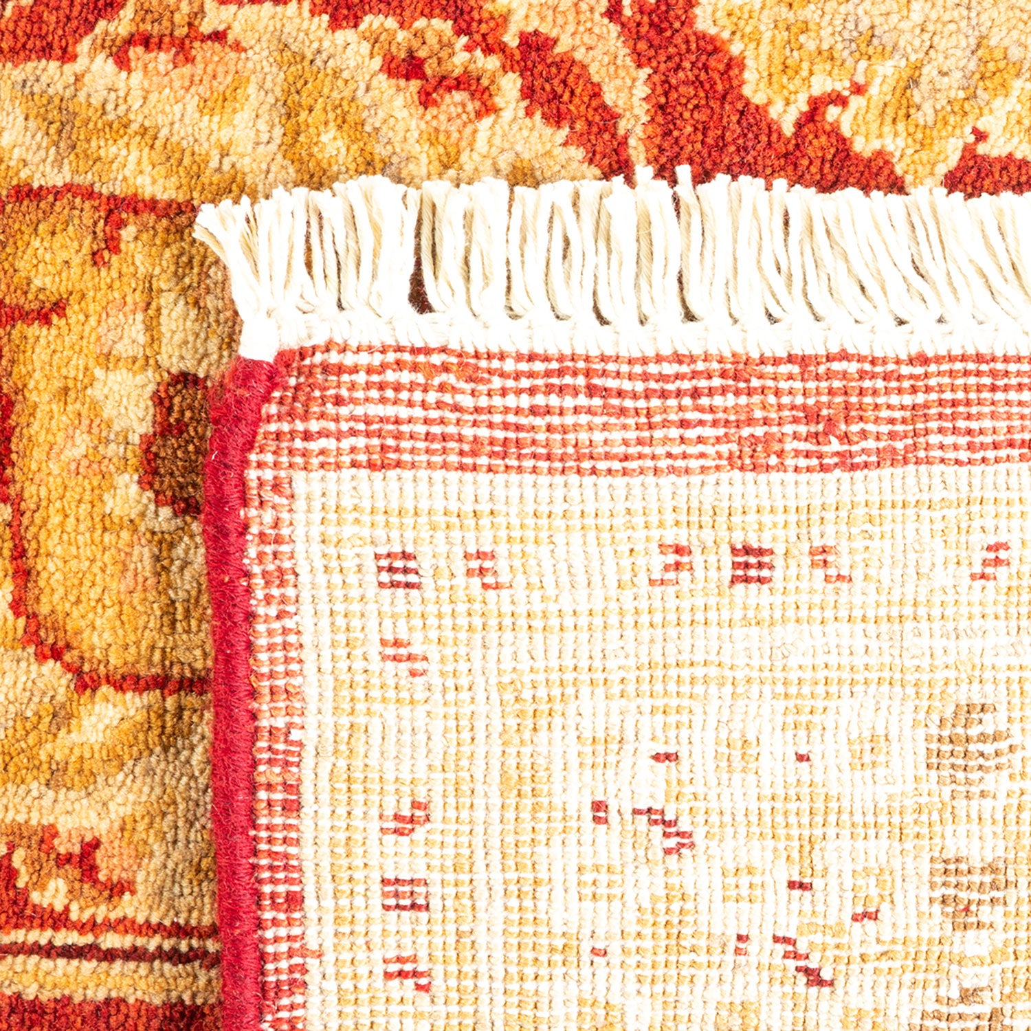 Close-up of a handmade rug featuring intricate pattern and fringe
