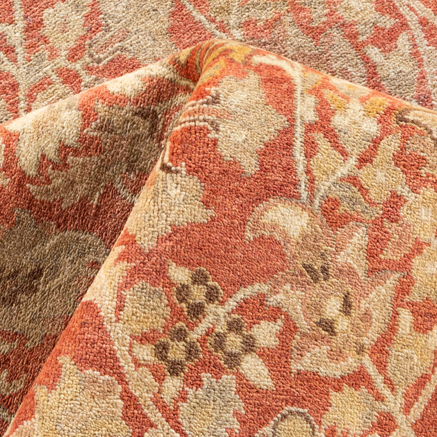 Close-up of a plush, floral-patterned carpet with warm earth tones.