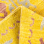 Close-up of a bright yellow loop pile carpet with intricate designs.
