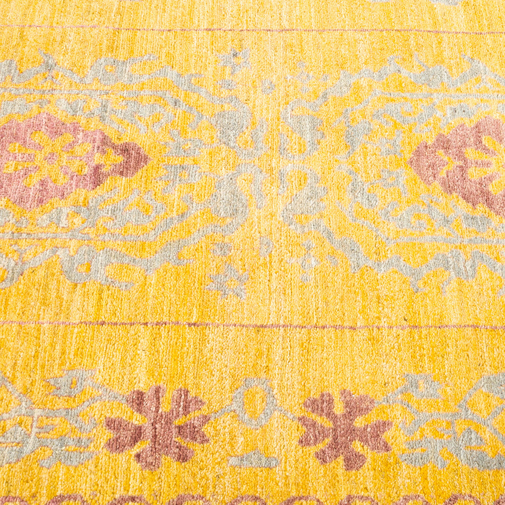 Patterned rug with dominant yellow background, symmetrical floral motifs.