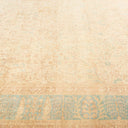 Large weathered vintage rug with faded turquoise and tan designs.