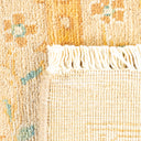Close-up of a handcrafted rug with golden yellow and teal pattern