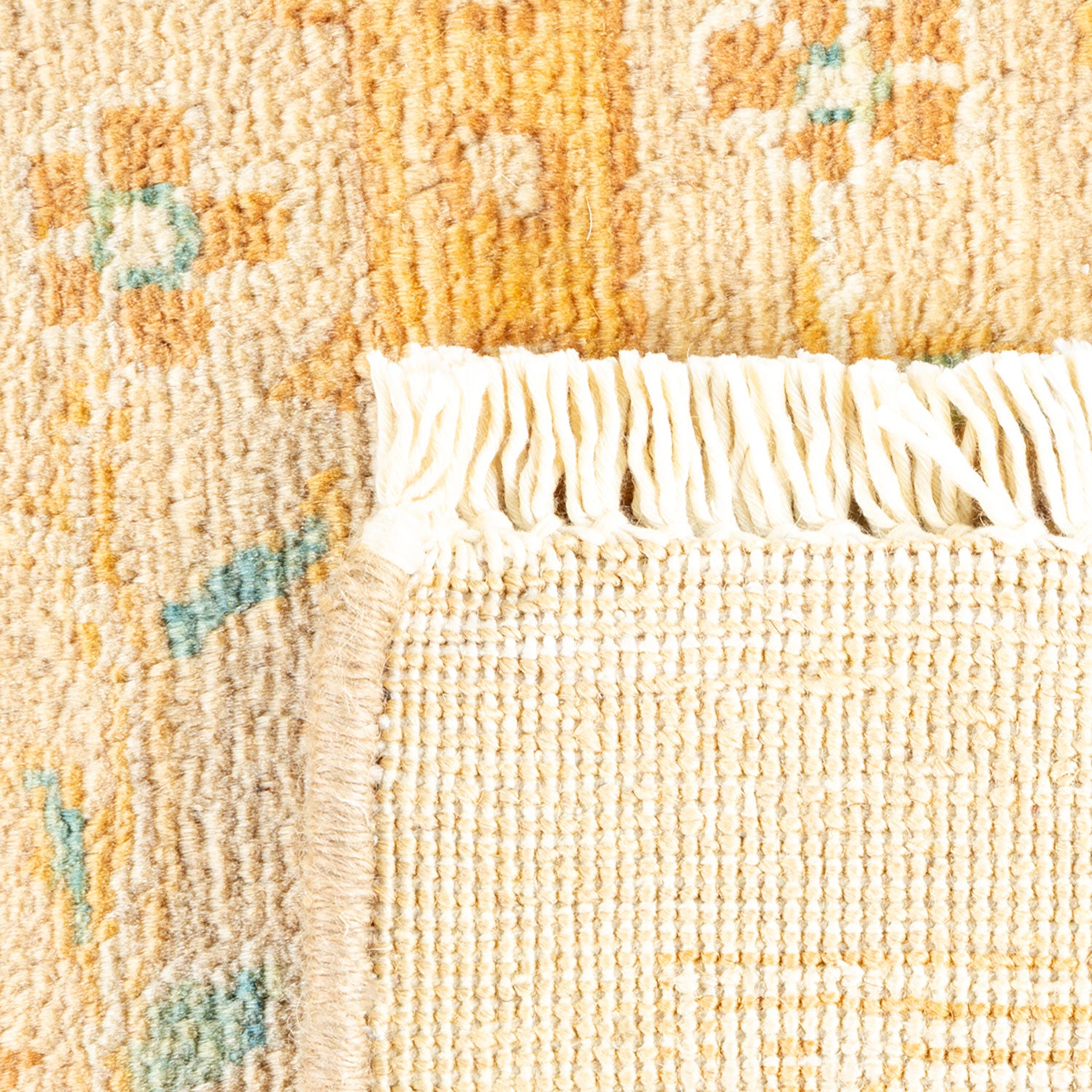 Close-up of a handcrafted rug with golden yellow and teal pattern