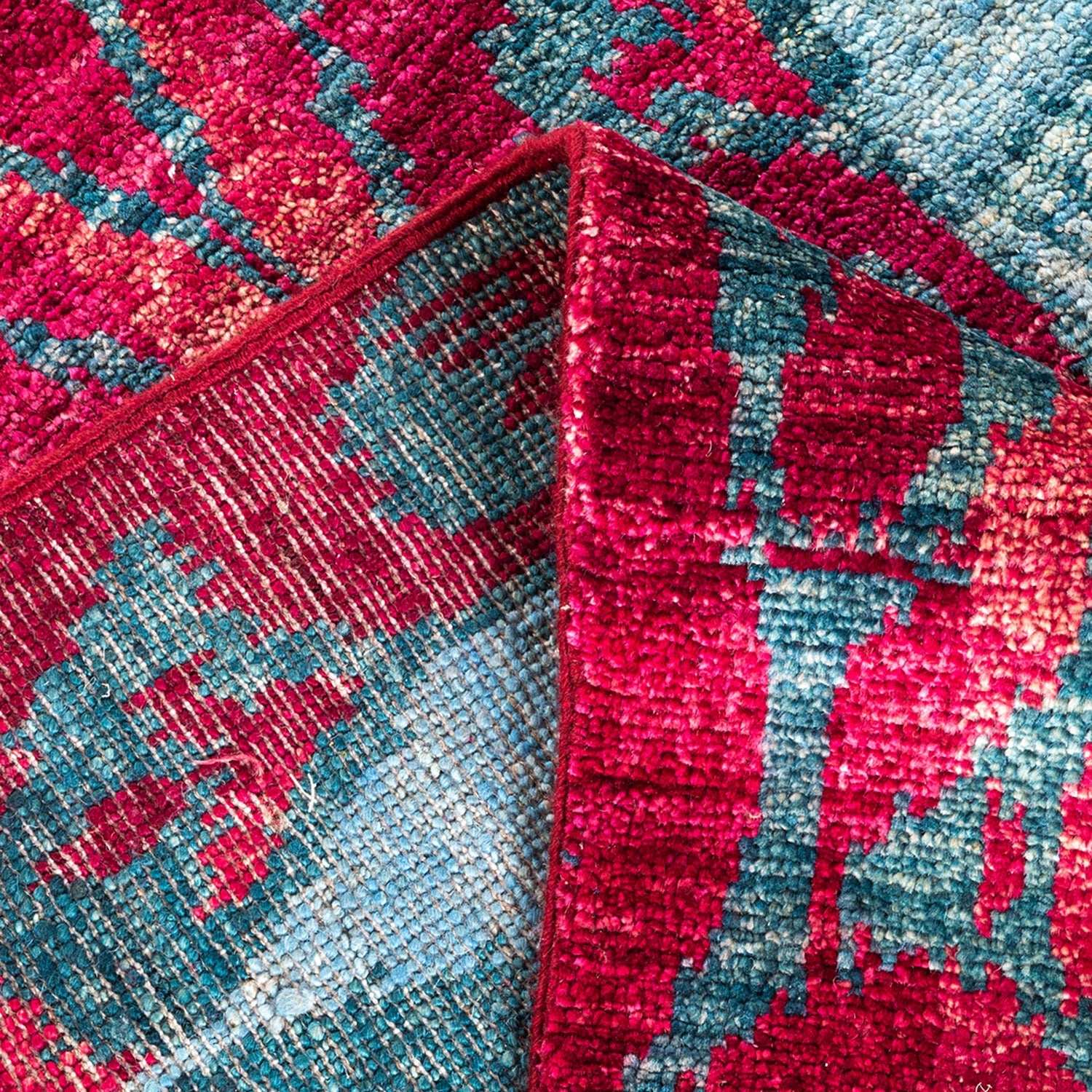 Close-up view of a red and blue woven textile's pattern.