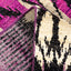 Close-up of intricately patterned textile in black, purple, pink, and beige.