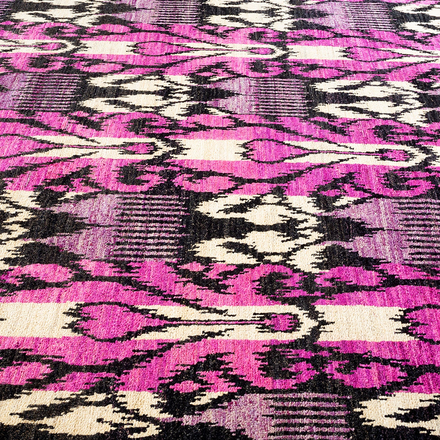 Close-up view of dynamic, opulent carpet with bold pattern.